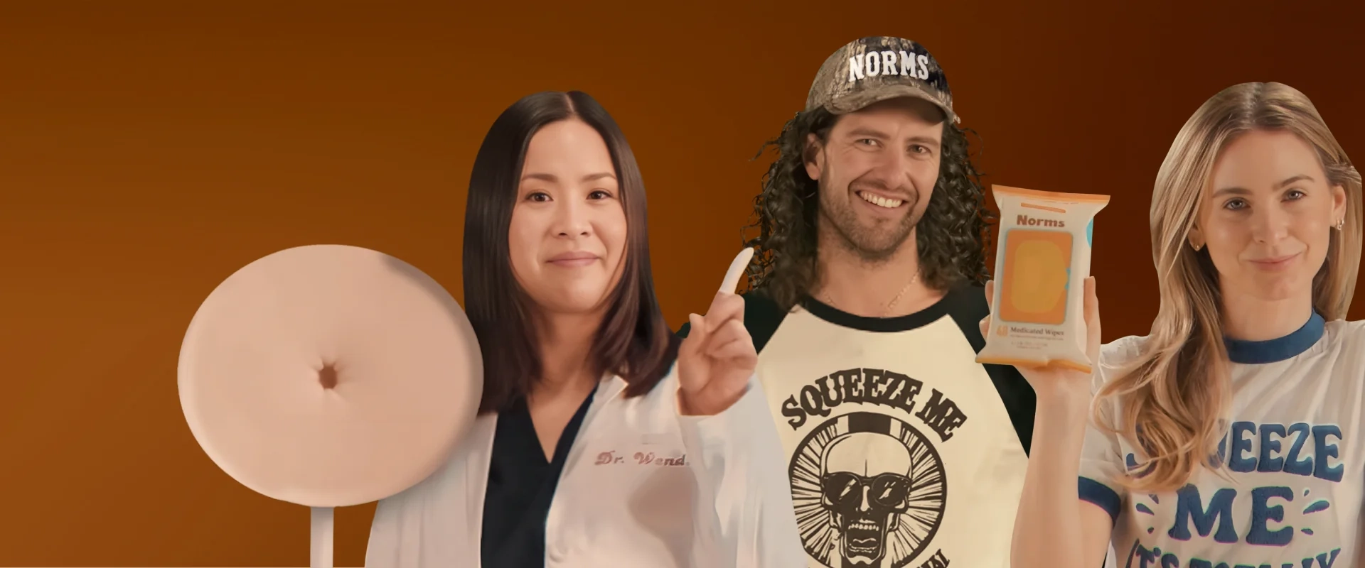 Three people holding a product against an orange background